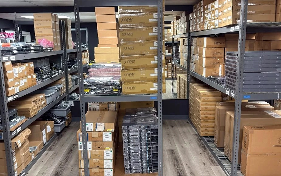 Parts shelving stocked with boxed switches, optics, and accessories