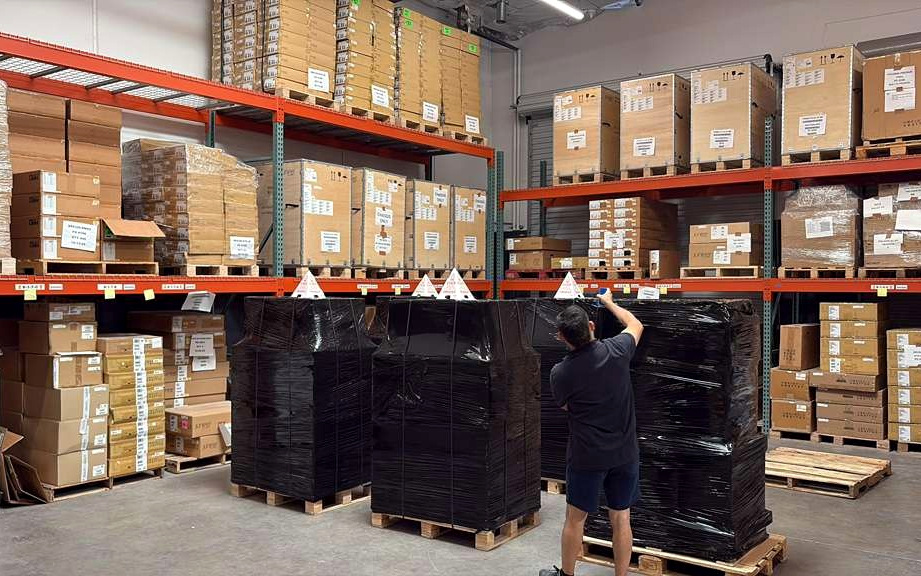 Wrapped outbound pallets being finished on the warehouse floor