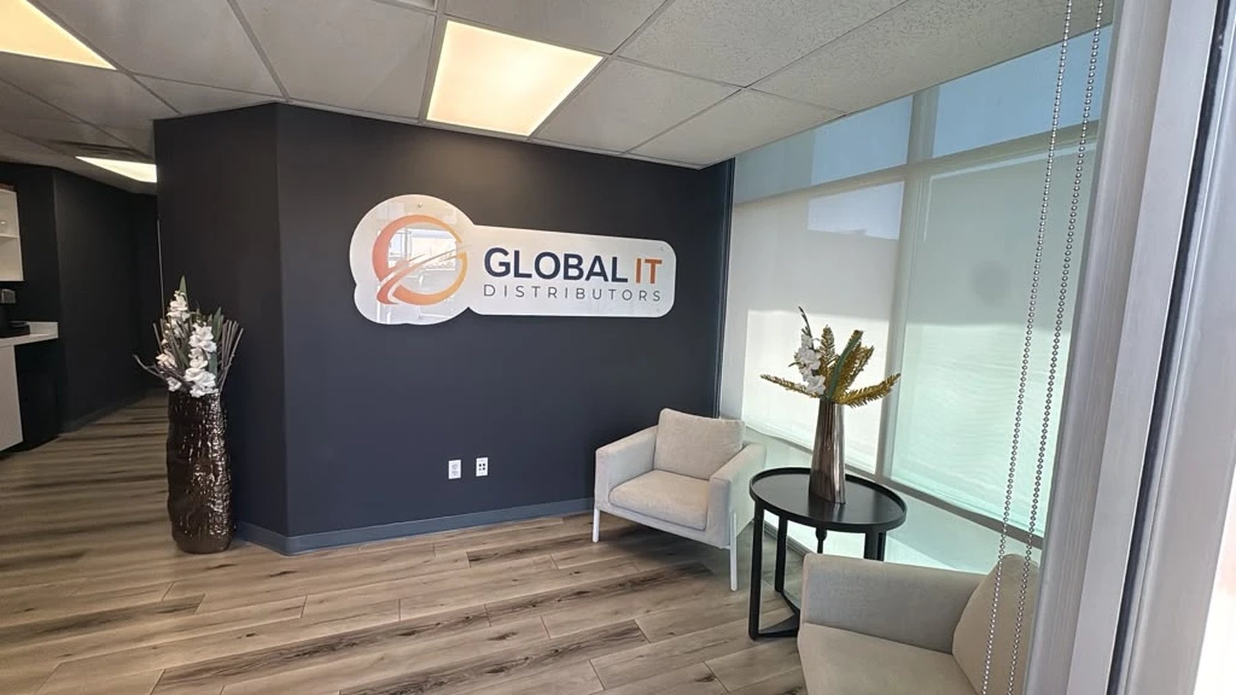 Reception at Global IT Distributors, with the wall sign above the seating area