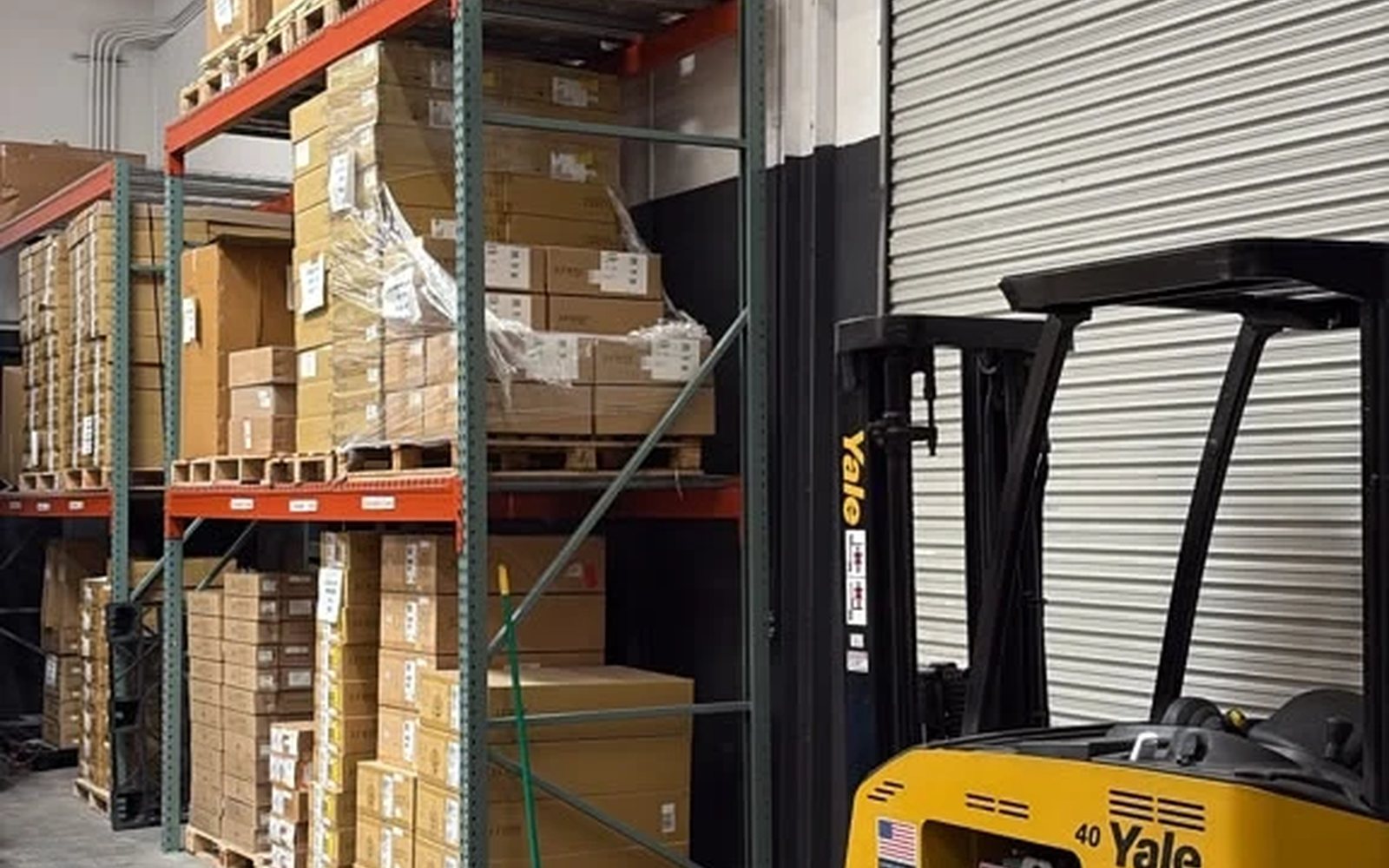 Pallet racking beside our loading dock and forklift, staged for worldwide dispatch
